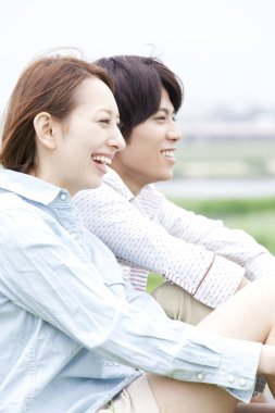 Genç Asyalı çift çimenlerin üzerinde rahatlatıcı