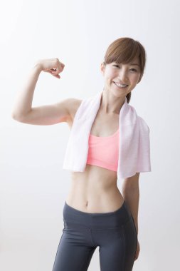 Genç sağlıklı Asyalı kadın egzersizden sonra şişeden su içiyor.