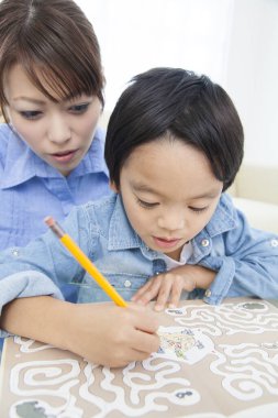 Asyalı anne ve oğul ödev yapıyor.
