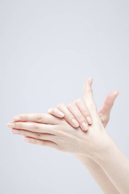 Beyaz arka planda el hareketi yapan kadınların yakın çekimi. 