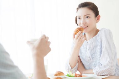 Güzel Asyalı kadın evde kocasıyla kahvaltı yapıyor.