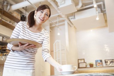 Gülümseyen Asyalı garson servis yapıyor.  