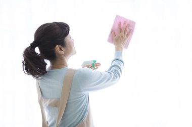 Camı bezle temizleyen Asyalı kadın.