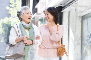 Sokakta yürüyen iki kadın konuşuyor.