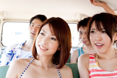 Minibüsle plaja giden Asyalı genç arkadaşlarının portresi. 