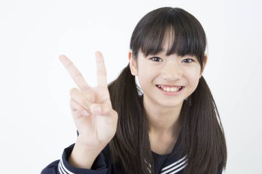 Beyaz stüdyo arka planında duran üniformalı Japon okul kızının portresi. 