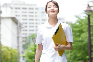 Parkta klasörü olan Asyalı kız öğrenci 