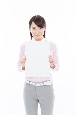 Tecrit edilmiş arka planda boş tahtası olan genç Asyalı iş kadını. 