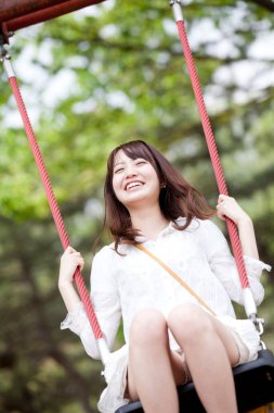 Mutlu Asyalı kadın salıncakta