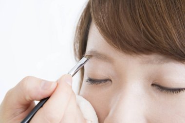 Güzellik salonunda makyaj yapan Asyalı güzel bir kadının yakın çekimi. 