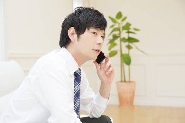 Kanepe üstünde smartphone ile genç adam 