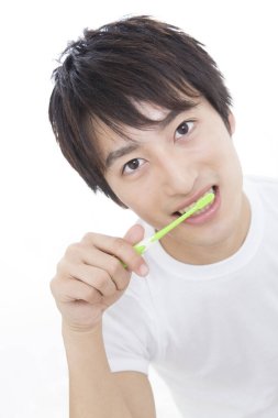 Diş fırçası tutan genç adam.