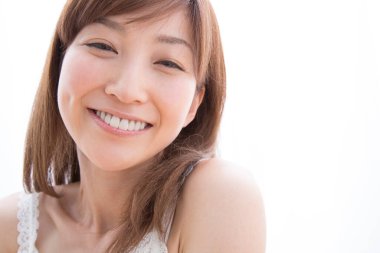 Evde gülümseyen Asyalı kadın.