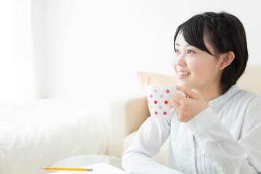 Kahve fincanı olan genç bir kadın.