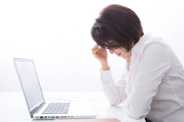 Ofiste dizüstü bilgisayarı olan stresli bir kadın. 