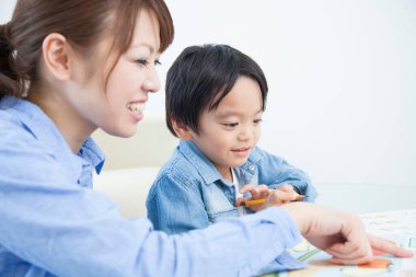 Asyalı anne ve oğul ödev yapıyor.