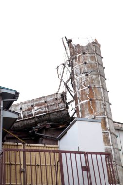 Metal çitlere dayanan hasarlı beton bina
