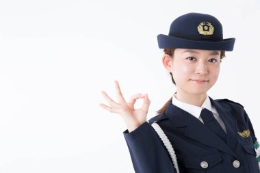 Pilot üniformalı genç bir kadın bir şey gösteriyor.