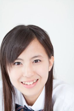 Okul üniformalı genç Japon kızın stüdyo portresi.