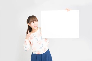 Beyaz arka planda boş işareti olan genç Asyalı kadın.