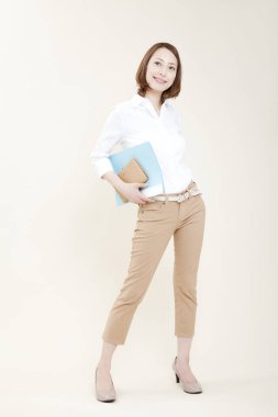 Stüdyoda poz veren dosyaları olan genç bir kadın.