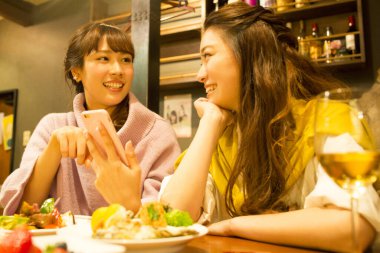 Genç Asyalı kadınlar restoranda yemek yiyorlar.