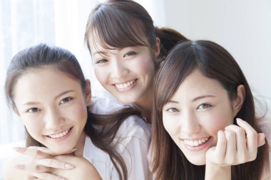 Üç gülümseyen Asyalı kadının portresini kapat.