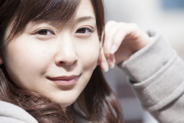 Genç ve güzel Asyalı bir kadının açık hava portresini kapat.