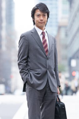 Sokakta yürüyen takım elbiseli Asyalı iş adamı 