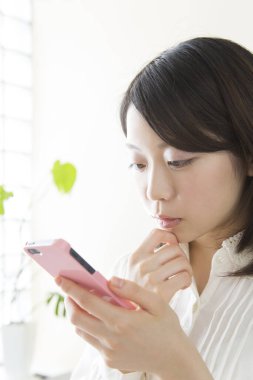 Cep telefonuna bakan bir kadın.