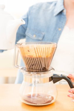 Genç bayan evde kahve yapıyor.