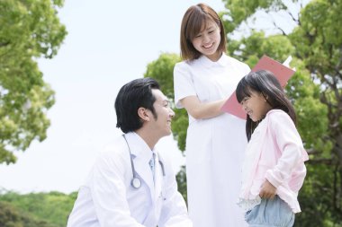 Parkta bir kızla birlikte Asyalı doktor ve hemşire  