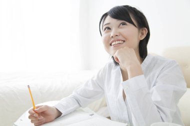 Güzel Asyalı genç kız evde çalışıyor.