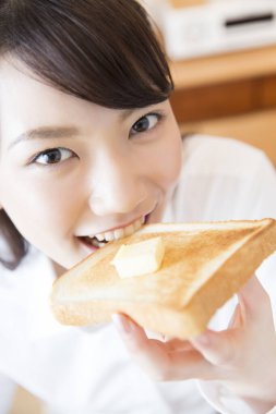 Japon aşçı kadın elinde ekmek tutuyor.