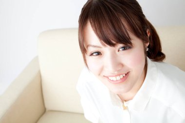 Kanepedeki genç Asyalı kadın portresi. 