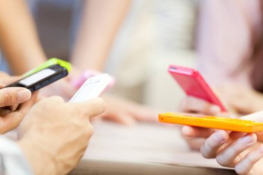 Masada renkli akıllı telefonlar kullanan insanlar.