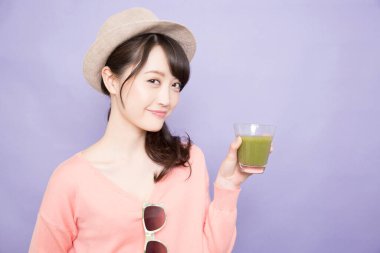 Elinde yeşil kibrit çayı tutan kadın.