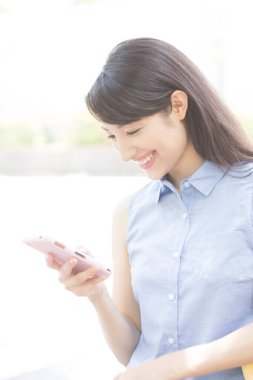 Akıllı telefon kullanan Asyalı genç kadının portresi