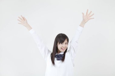 Beyaz gömlekli kadın ellerini kaldırıyor.