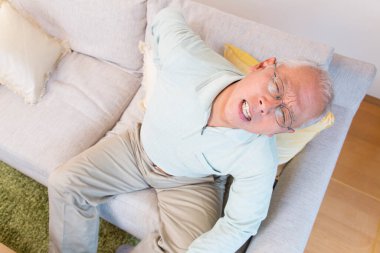 Evde acı çeken yaşlı Asyalı adam.