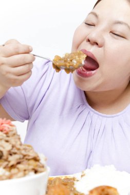 Şişman Asyalı kadın et yiyor. Stüdyo resmi