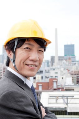 İnşaat alanında miğferli Asyalı mühendis