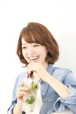 Güzel Japon kadın naneli ferahlatıcı soğuk içecek içiyor.