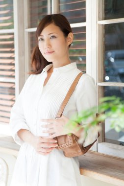 Asyalı güzel bir kadının portresi bina kenarında duruyor. 