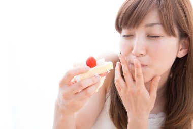 Çilekli kek yiyen bir kadın.