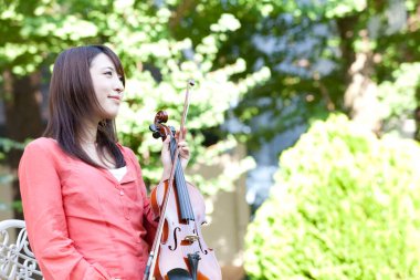 Kemanı olan genç Asyalı kadın.
