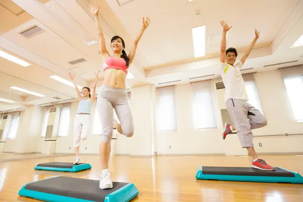 Modern spor salonunda spor yapan genç Japonlar.