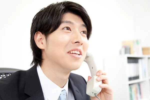 Uśmiechnięty Azjatycki Biznesmen Rozmawiający Przez Telefon Miejscu Pracy — Zdjęcie stockowe