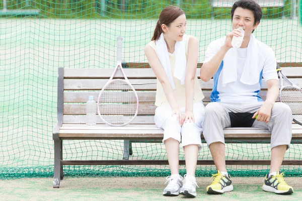 Junger Mann Und Frau Nach Tennisspiel Auf Bank — Stockfoto