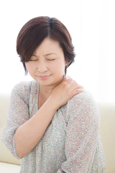 Sırt ağrısı çeken genç Asyalı kadın..